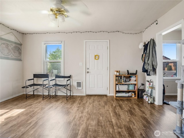 entryway with heating unit, a ceiling fan, and wood finished floors