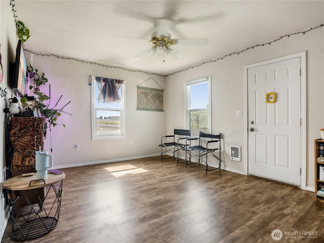 interior space with baseboards, ceiling fan, and wood finished floors
