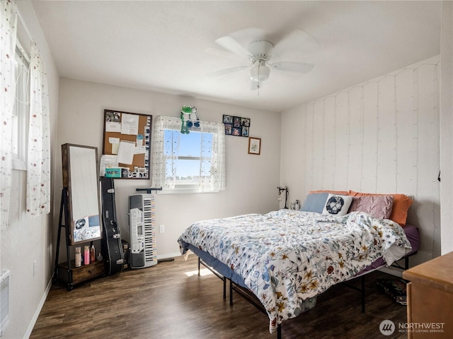bedroom with baseboards, a ceiling fan, wood finished floors, and visible vents