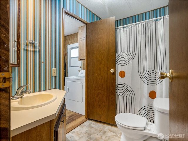 bathroom with vanity, toilet, wallpapered walls, washer / dryer, and curtained shower