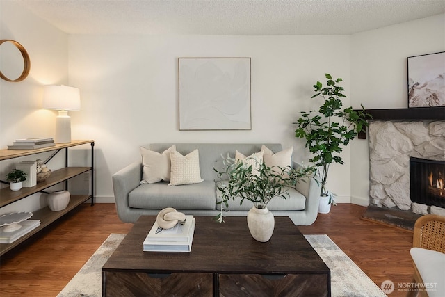 2411 S 248th St Unit D22, Kent, WA 98032 - living area with a stone fireplace, wood finished floors, and baseboards