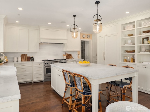 kitchen with light stone counters, high end stainless steel range, a breakfast bar, and custom exhaust hood