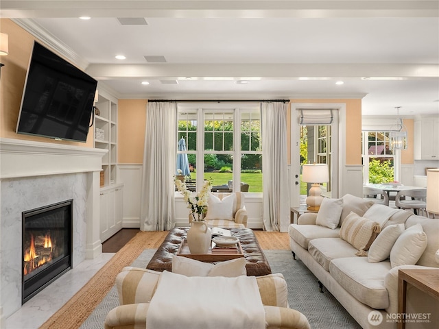living area with ornamental molding, a fireplace, recessed lighting, and a wealth of natural light