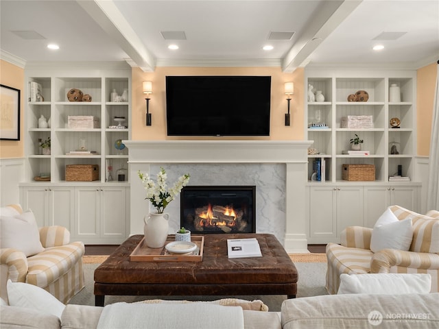 living area featuring crown molding, built in features, a fireplace, beamed ceiling, and recessed lighting