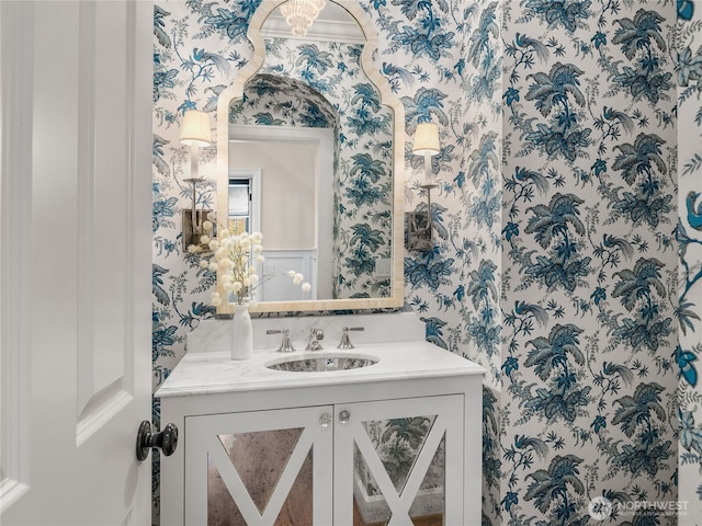 bathroom with vanity and wallpapered walls