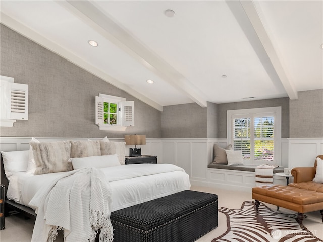carpeted bedroom with a wainscoted wall, wallpapered walls, vaulted ceiling with beams, a decorative wall, and recessed lighting