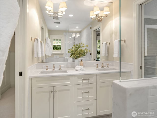 full bath with visible vents, a sink, and a notable chandelier
