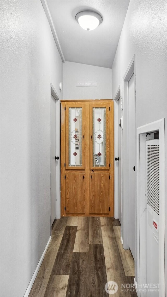 hallway with a heating unit and wood finished floors