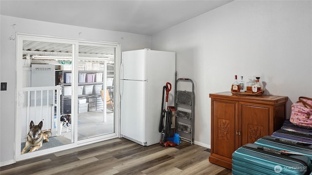 bedroom with freestanding refrigerator, wood finished floors, access to exterior, and baseboards