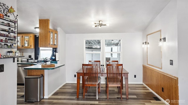 dining area with dark wood finished floors, a chandelier, and baseboards