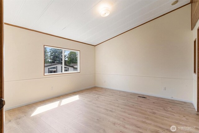 unfurnished room with crown molding, light wood-style flooring, lofted ceiling, and baseboards