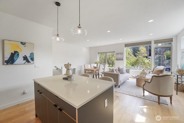3236 W Government Way, Seattle, WA 98199 - kitchen with pendant lighting, a center island, light wood-type flooring, light countertops, and recessed lighting