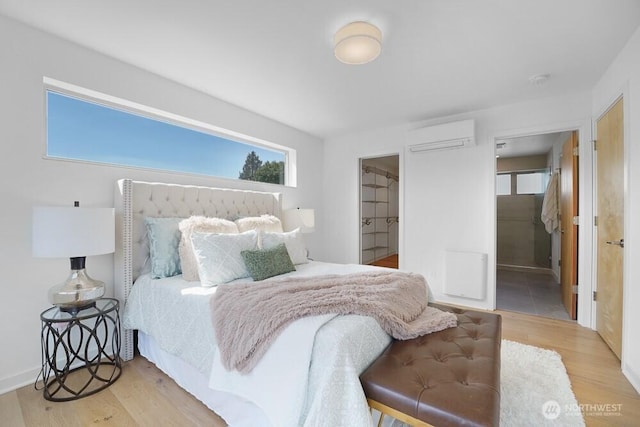 3236 W Government Way, Seattle, WA 98199 - bedroom featuring a wall mounted AC, ensuite bath, and wood finished floors