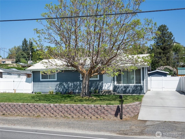 view of front of house with fence, driveway, and a front yard