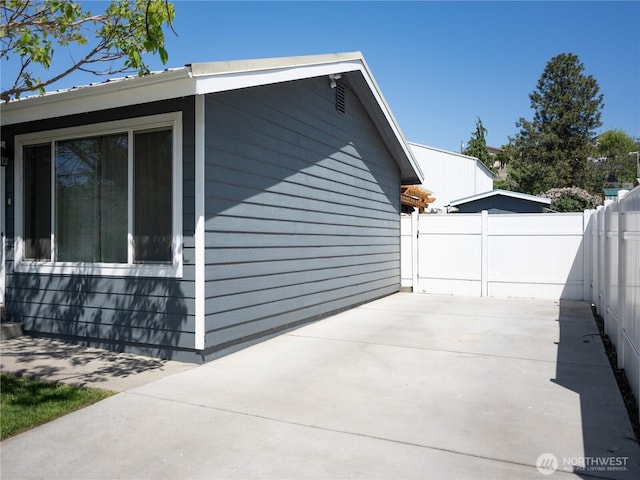 view of side of home with a patio and fence