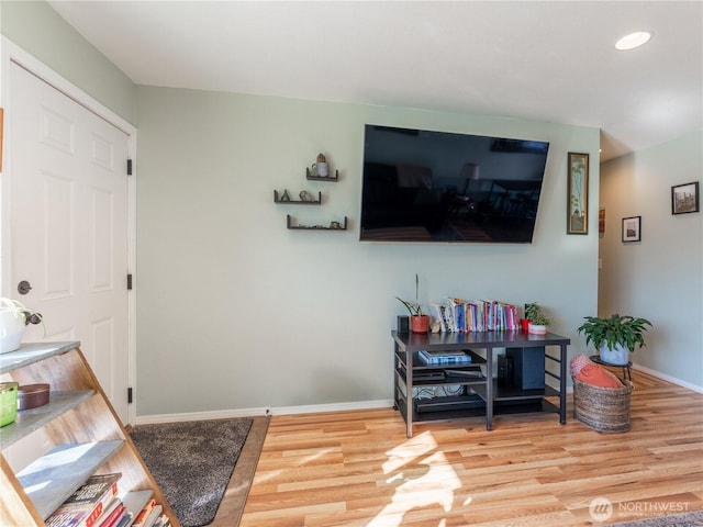 living area with recessed lighting, baseboards, and wood finished floors