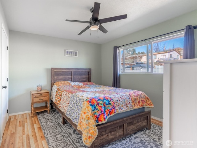 bedroom featuring baseboards, ceiling fan, and wood finished floors