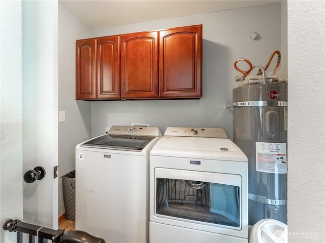 clothes washing area with secured water heater, cabinet space, and washing machine and clothes dryer