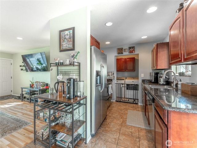 kitchen with stainless steel fridge, a sink, dark stone counters, and recessed lighting