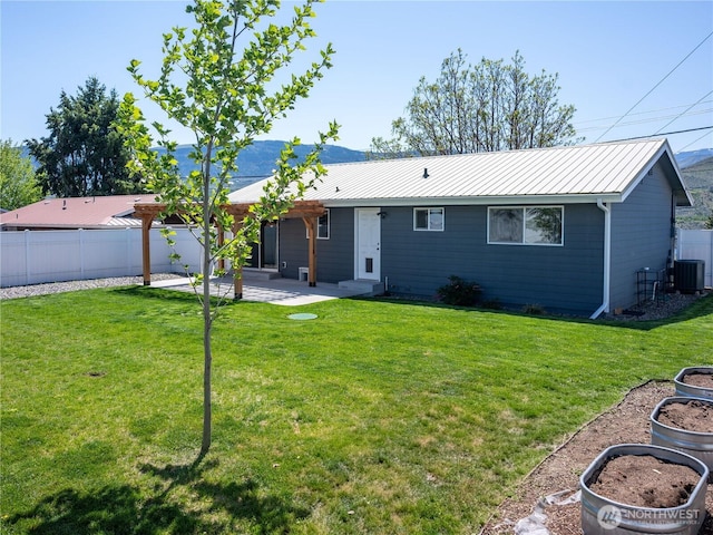 back of house featuring fence, central AC unit, a yard, and a patio area