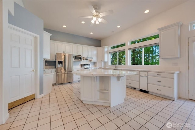 kitchen with light countertops, a ceiling fan, stainless steel appliances, and white cabinetry