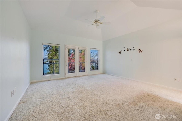 carpeted spare room featuring high vaulted ceiling, baseboards, and a ceiling fan