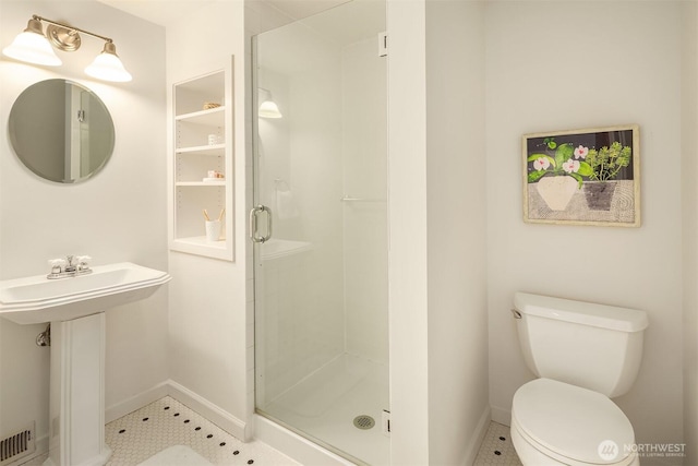 full bath featuring toilet, baseboards, a sink, and a stall shower