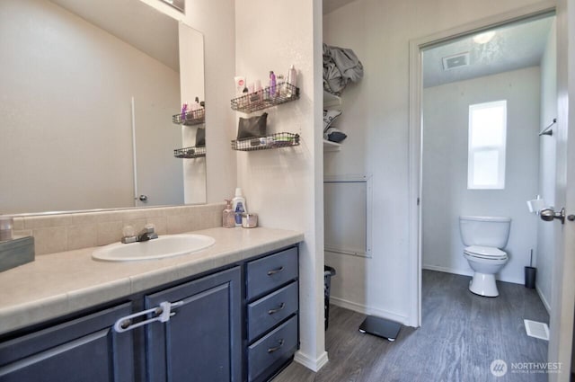 117 Hewitt Rd, Chehalis, WA 98532 - bathroom with vanity, visible vents, wood finished floors, toilet, and backsplash