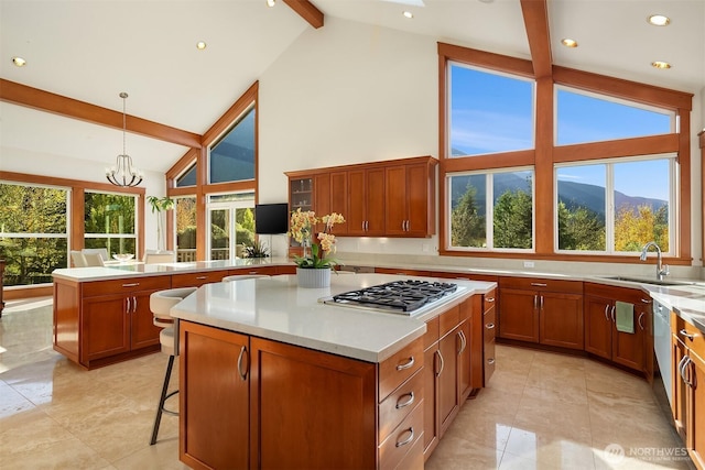 15803 Uplands Way SE, North Bend, WA 98045 - kitchen featuring a sink, beam ceiling, stainless steel gas cooktop, a peninsula, and brown cabinetry
