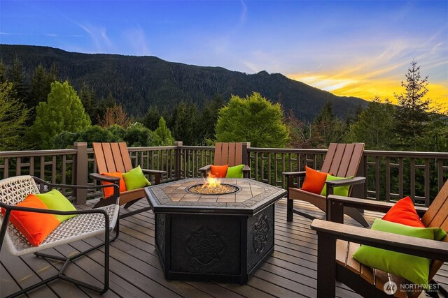 15803 Uplands Way SE, North Bend, WA 98045 - deck at dusk with a fire pit, a mountain view, and a forest view