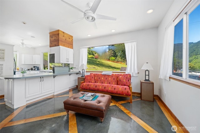 living room featuring baseboards, a ceiling fan, and recessed lighting