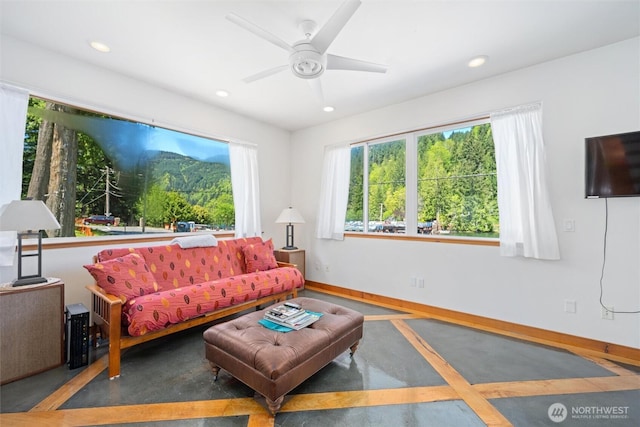 living area featuring a ceiling fan, baseboards, and recessed lighting