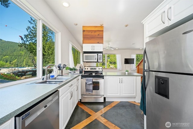 kitchen with white cabinets, appliances with stainless steel finishes, and a sink
