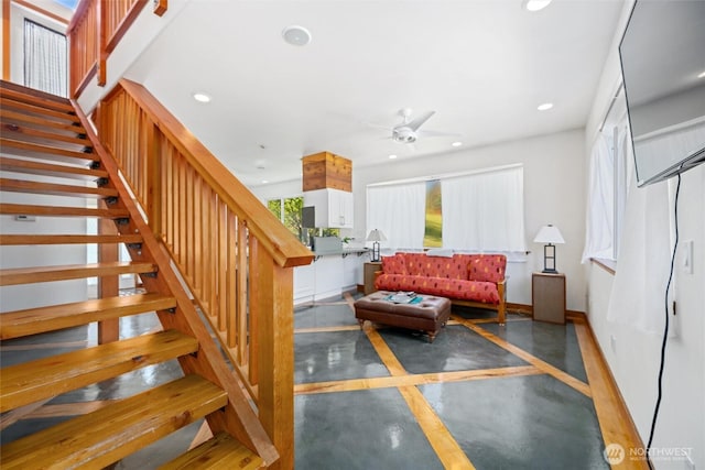 staircase with a ceiling fan, recessed lighting, finished concrete floors, and a wealth of natural light