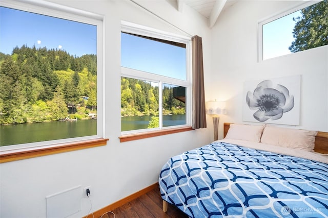 bedroom with a water view, baseboards, and wood finished floors
