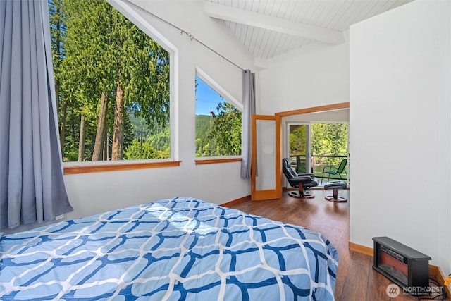 bedroom with lofted ceiling with beams, baseboards, and wood finished floors