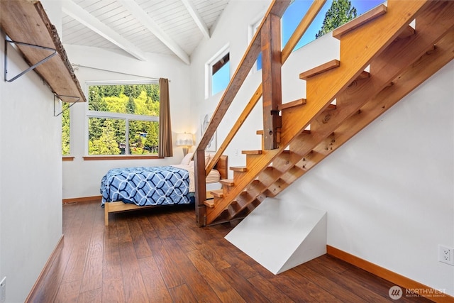 bedroom with lofted ceiling with beams, wood-type flooring, baseboards, and wood ceiling