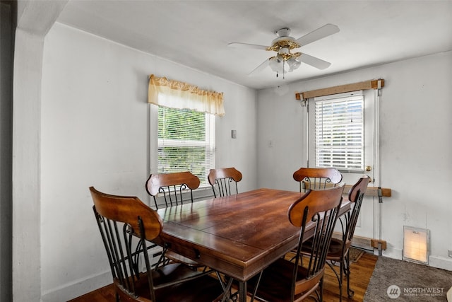 dining area with wood finished floors, a ceiling fan, and baseboards