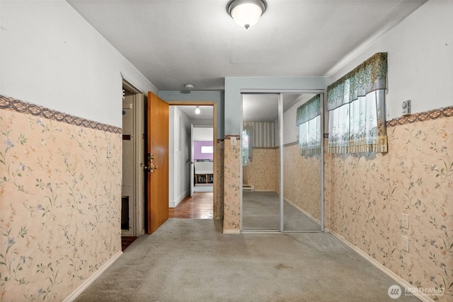 hallway featuring healthy amount of natural light, carpet floors, and wallpapered walls