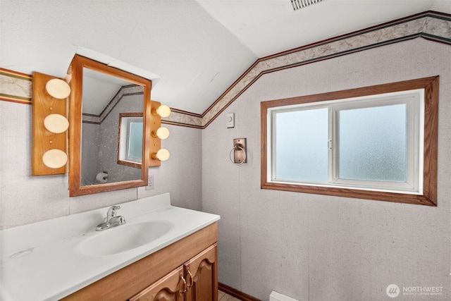 bathroom with lofted ceiling and vanity