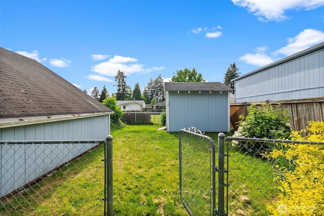 view of yard featuring a shed, an outdoor structure, and a gate