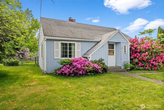 view of front of house with a chimney and a front lawn
