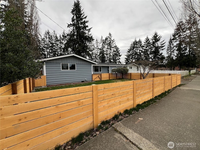 view of home's exterior featuring board and batten siding and fence private yard