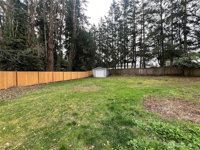 view of yard with an outdoor structure, a shed, and a fenced backyard