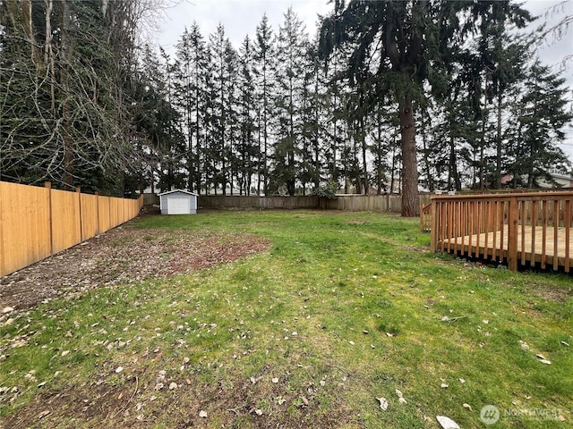 view of yard featuring a fenced backyard, a shed, and an outbuilding