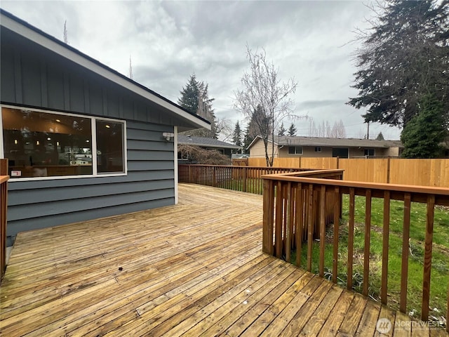 wooden deck with a fenced backyard