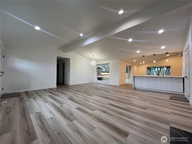 unfurnished living room featuring recessed lighting, baseboards, lofted ceiling with beams, and light wood-type flooring