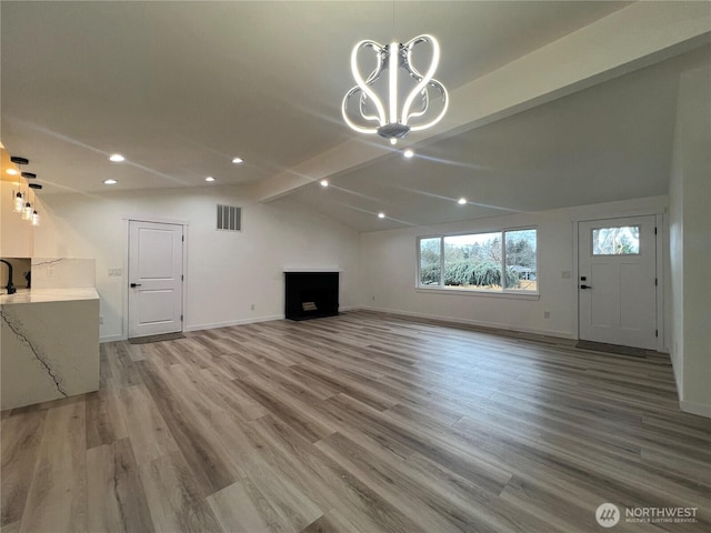 unfurnished living room featuring visible vents, wood finished floors, baseboards, vaulted ceiling with beams, and recessed lighting