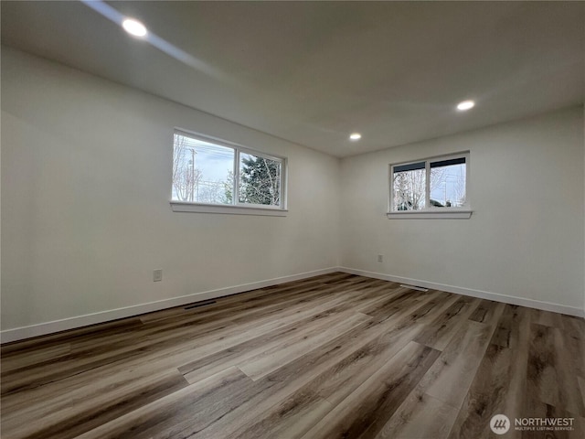 spare room with baseboards, recessed lighting, and wood finished floors