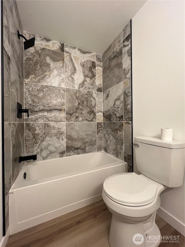 bathroom featuring wood finished floors, bathing tub / shower combination, and toilet